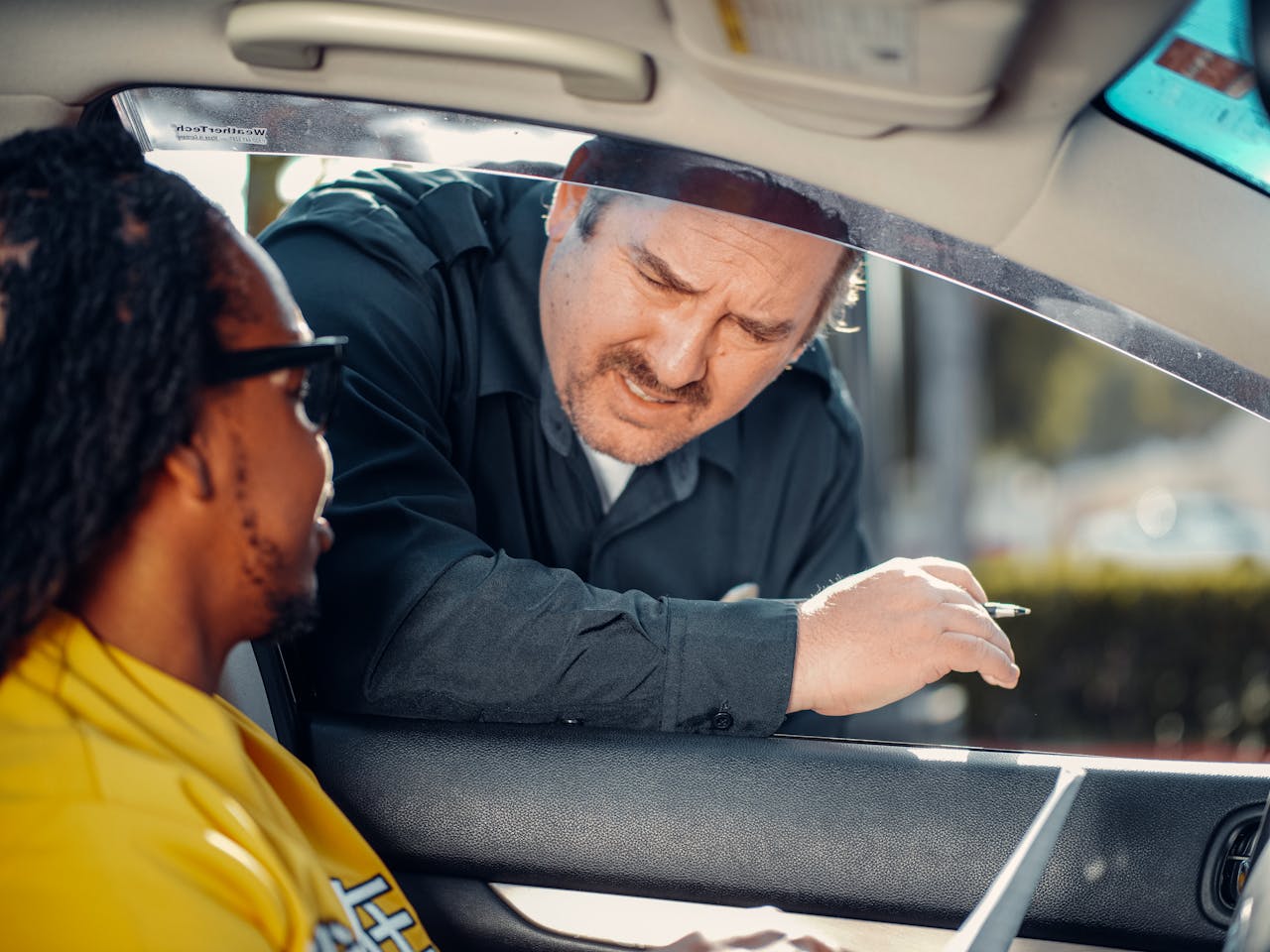 A police officer interacts with a driver through a car window, emphasizing law enforcement and public safety.